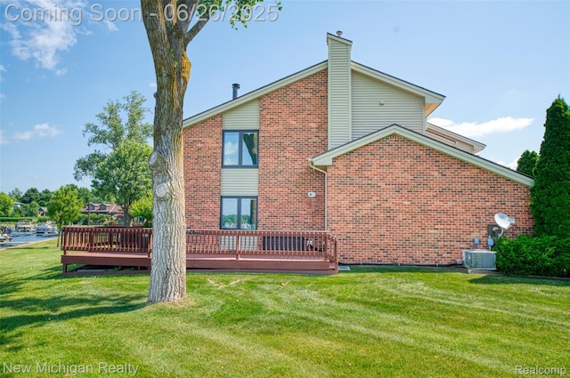 2226 Bowles St, Fenton, MI 48430 - rear view of house with a deck, a lawn, brick siding, and a chimney