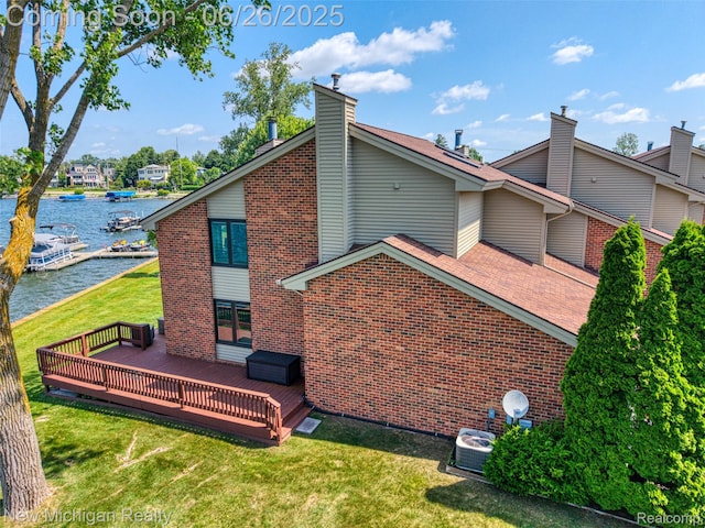 2226 Bowles St, Fenton, MI 48430 - back of house featuring brick siding, a lawn, a deck with water view, and a chimney