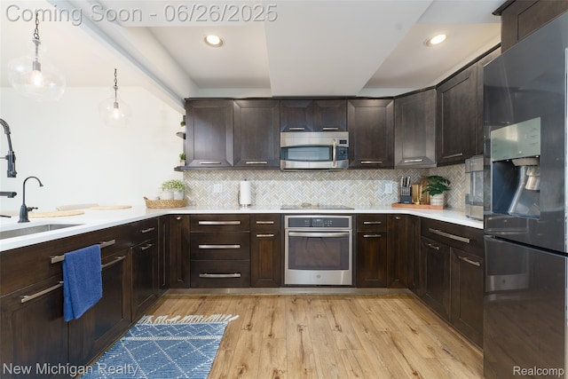 2226 Bowles St, Fenton, MI 48430 - kitchen with appliances with stainless steel finishes, dark brown cabinets, light countertops, decorative backsplash, and recessed lighting