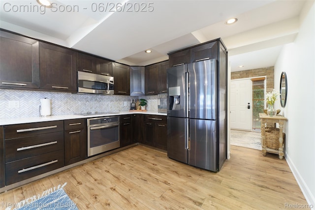 2226 Bowles St, Fenton, MI 48430 - kitchen with stainless steel appliances, dark brown cabinetry, light countertops, tasteful backsplash, and recessed lighting