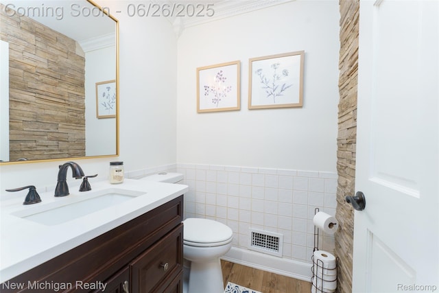 2226 Bowles St, Fenton, MI 48430 - bathroom with tile walls, vanity, crown molding, wood finished floors, and wainscoting