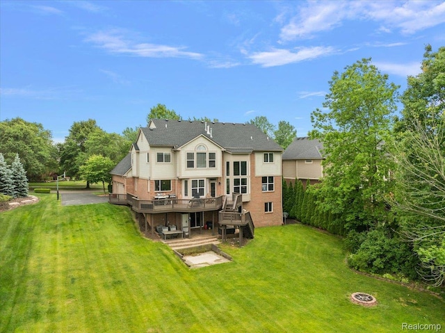 5390 Plantation Dr, Commerce Twp, MI 48382 - back of property featuring a wooden deck, a lawn, a patio area, an outdoor fire pit, and brick siding