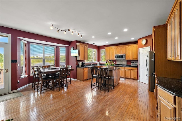 5390 Plantation Dr, Commerce Twp, MI 48382 - kitchen featuring appliances with stainless steel finishes, a center island, light wood-type flooring, recessed lighting, and brown cabinets