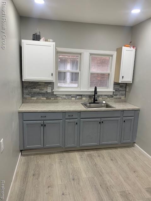 12066 N Martindale St, Detroit, MI 48204 - kitchen with gray cabinetry, light wood-type flooring, backsplash, light countertops, and recessed lighting