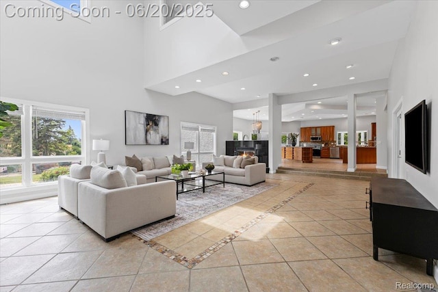 3440 Lone Pine Rd, West Bloomfield, MI 48323 - living room with inlaid floor details, a towering ceiling, recessed lighting, healthy amount of natural light, and a glass covered fireplace