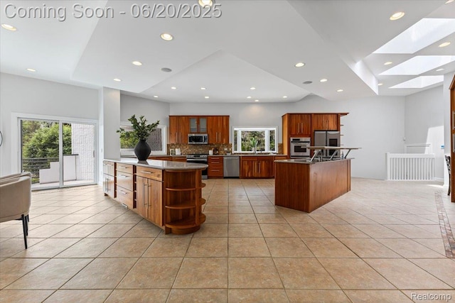 3440 Lone Pine Rd, West Bloomfield, MI 48323 - kitchen with appliances with stainless steel finishes, a center island, light tile patterned floors, a skylight, and open shelves