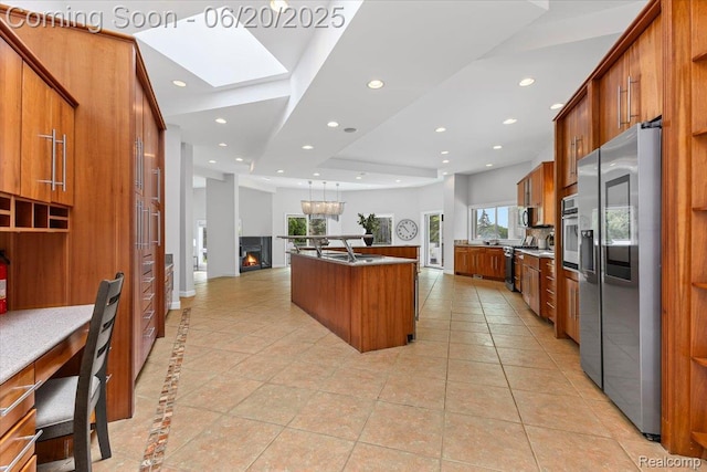 3440 Lone Pine Rd, West Bloomfield, MI 48323 - kitchen with appliances with stainless steel finishes, brown cabinets, recessed lighting, a skylight, and a kitchen island with sink
