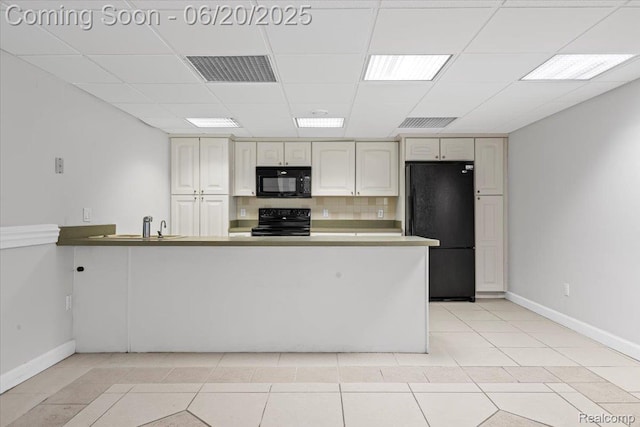 3440 Lone Pine Rd, West Bloomfield, MI 48323 - kitchen with black appliances, a peninsula, light tile patterned flooring, a paneled ceiling, and tasteful backsplash
