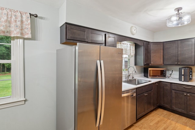 70838 Ridgewood Dr, Edwardsburg, MI 49112 - kitchen with appliances with stainless steel finishes, dark brown cabinets, light countertops, and light wood finished floors