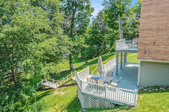 13674 Lenore Dr, Hudson, MI 49247 - wooden deck with outdoor dining area, a lawn, and view of scattered trees