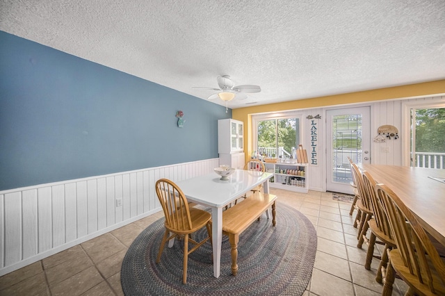 13674 Lenore Dr, Hudson, MI 49247 - dining room with plenty of natural light, a ceiling fan, a wainscoted wall, a textured ceiling, and light tile patterned flooring