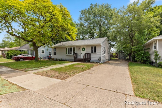 1235 Aurora Ave, Muskegon, MI 49442 - view of front of home featuring concrete driveway, a front lawn, and an outbuilding