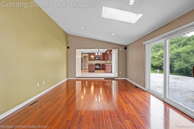 34516 Bunker Hill Dr, Farmington, MI 48331 - unfurnished living room featuring vaulted ceiling, light wood-style floors, a skylight, and recessed lighting