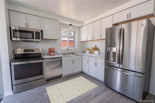 8177 Gary Ave, Westland, MI 48185 - kitchen with stainless steel appliances, light countertops, light wood-type flooring, and white cabinets