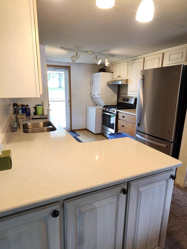 368 Old Hickory Dr, Coldwater, MI 49036 - kitchen featuring appliances with stainless steel finishes, stacked washing machine and dryer, light stone countertops, track lighting, and under cabinet range hood