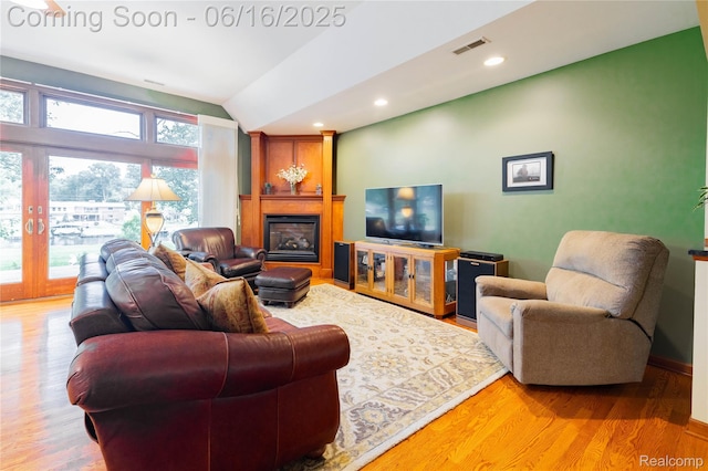 21781 Thorofare Rd, Grosse Ile, MI 48138 - living room with vaulted ceiling, light wood-style floors, a glass covered fireplace, and recessed lighting