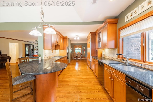 21781 Thorofare Rd, Grosse Ile, MI 48138 - kitchen with black dishwasher, dishwasher, a kitchen breakfast bar, light wood-style flooring, and brown cabinets