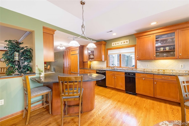 21781 Thorofare Rd, Grosse Ile, MI 48138 - kitchen with dishwasher, brown cabinetry, light wood-style flooring, a breakfast bar, and tasteful backsplash