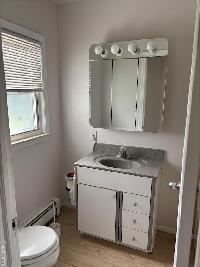 59 W High St, Metamora, MI 48455 - bathroom with baseboard heating, vanity, and wood finished floors