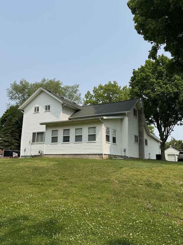 1026 Yeomans St, Ionia, MI 48846 - back of property with a lawn and a shingled roof