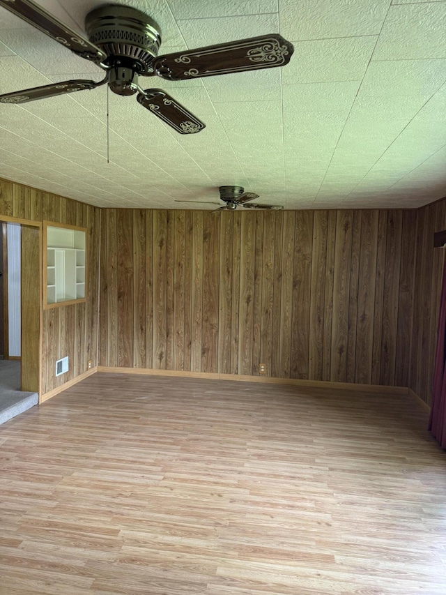 1026 Yeomans St, Ionia, MI 48846 - spare room with ceiling fan, light wood finished floors, and wood walls