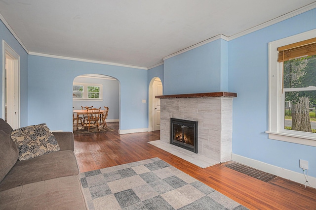 5147 N Riverview Dr, Kalamazoo, MI 49004 - living area with arched walkways, wood finished floors, ornamental molding, and a tile fireplace