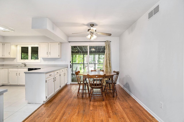 6958 Paddock Ln, Jackson, MI 49201 - kitchen featuring light countertops, white cabinetry, ceiling fan, and a peninsula