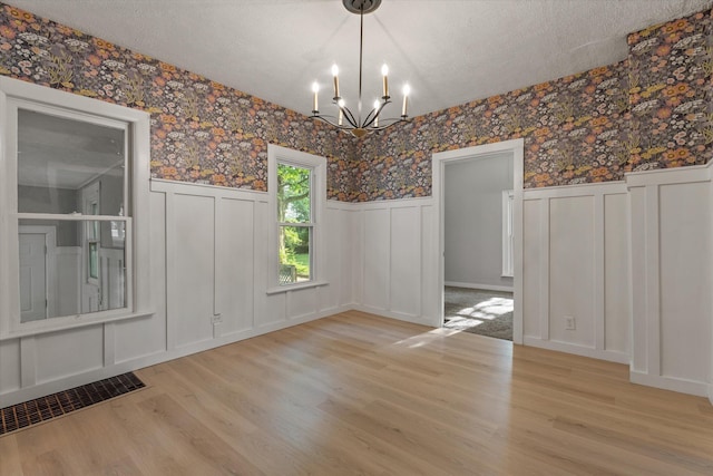 1334 Regent St, Niles, MI 49120 - unfurnished dining area featuring a decorative wall, wallpapered walls, a chandelier, wainscoting, and wood finished floors