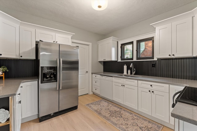 1334 Regent St, Niles, MI 49120 - kitchen with stainless steel fridge with ice dispenser, white dishwasher, white cabinets, and light wood finished floors