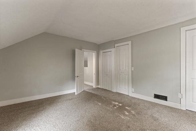 1334 Regent St, Niles, MI 49120 - unfurnished bedroom featuring carpet flooring, two closets, and vaulted ceiling