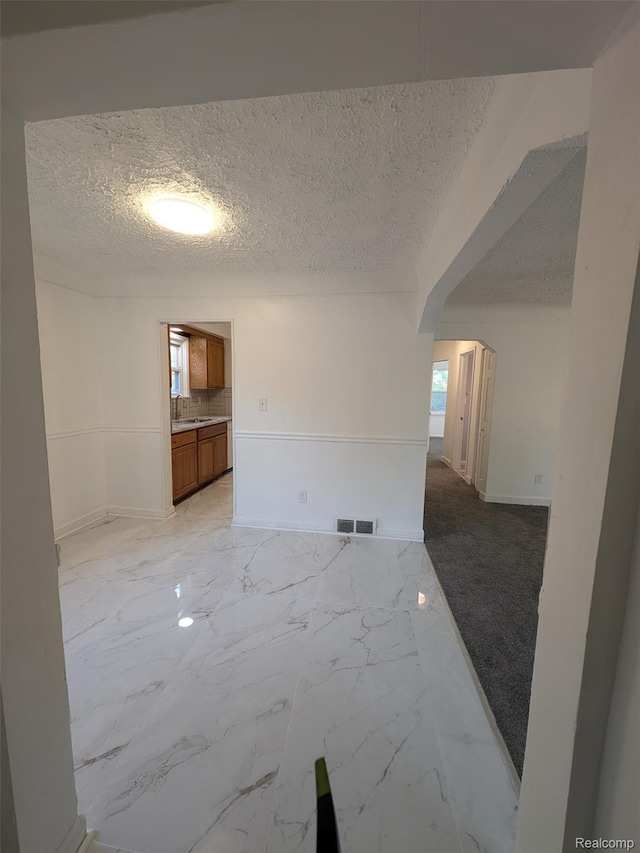 19947 Kinloch, Redford, MI 48240 - empty room with arched walkways, a textured ceiling, and light marble finish flooring