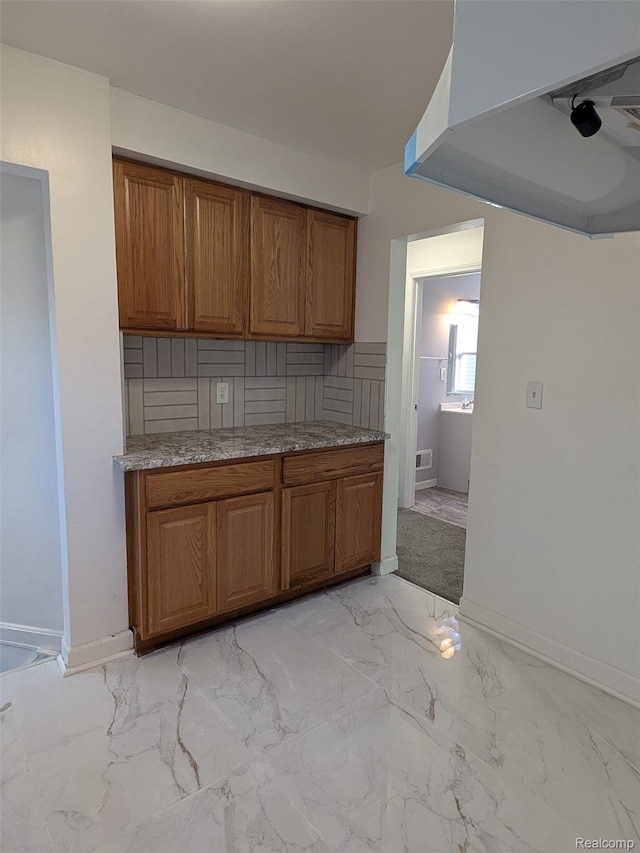 19947 Kinloch, Redford, MI 48240 - kitchen featuring brown cabinets, light marble finish flooring, light countertops, and exhaust hood