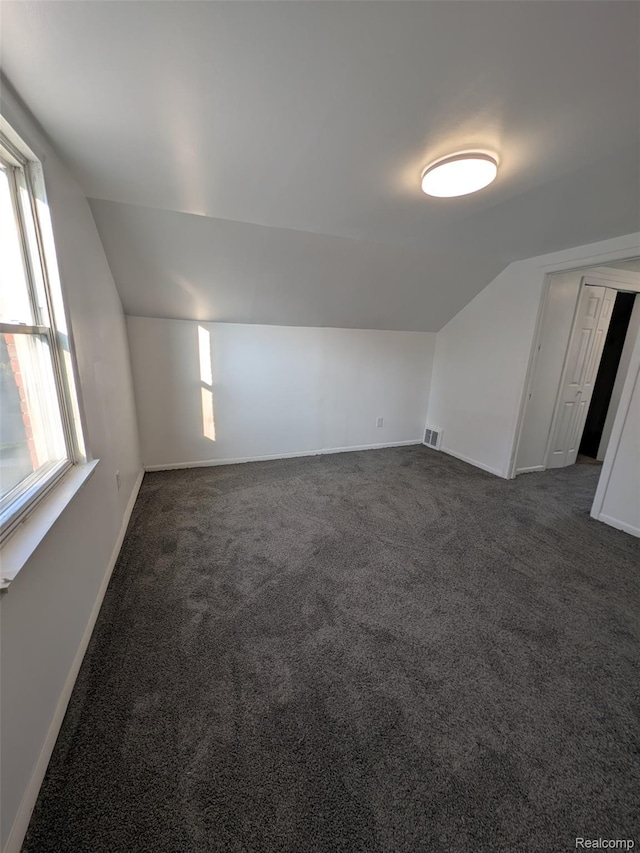 19947 Kinloch, Redford, MI 48240 - additional living space with vaulted ceiling, dark carpet, and plenty of natural light