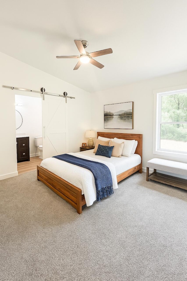2959 Polaris Ave, Kalamazoo, MI 49004 - bedroom featuring a barn door, carpet flooring, vaulted ceiling, ceiling fan, and ensuite bath