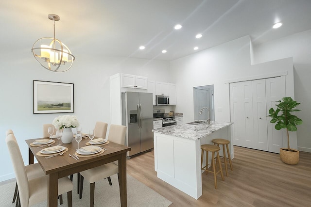 2959 Polaris Ave, Kalamazoo, MI 49004 - kitchen with appliances with stainless steel finishes, light wood-style floors, a chandelier, recessed lighting, and a center island with sink