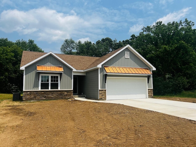2959 Polaris Ave, Kalamazoo, MI 49004 - craftsman-style home with stone siding, board and batten siding, concrete driveway, a shingled roof, and an attached garage