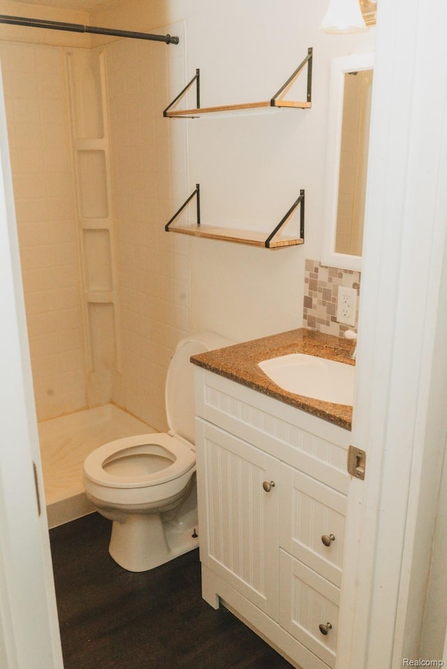 11709 Old Belding Rd NE, Belding, MI 48809 - bathroom with a shower stall, vanity, wood finished floors, and tasteful backsplash