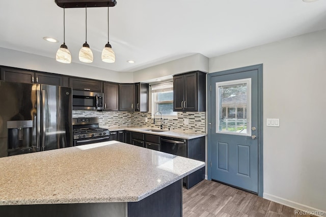 31740 Nelson Dr, Warren, MI 48088 - kitchen with stainless steel appliances, tasteful backsplash, light wood-type flooring, decorative light fixtures, and light stone counters