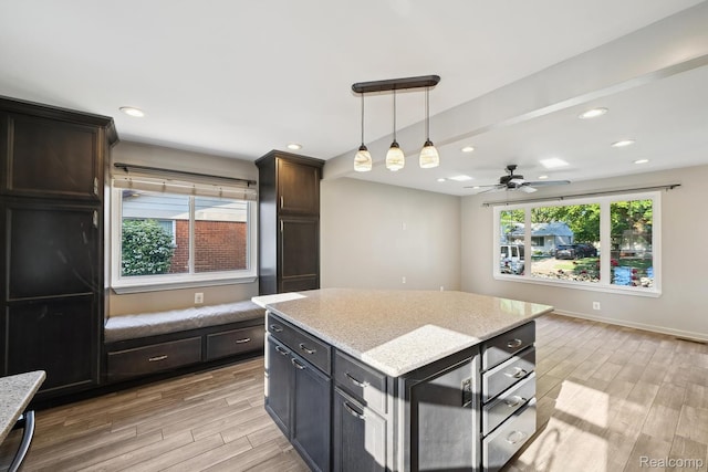 31740 Nelson Dr, Warren, MI 48088 - kitchen with light wood-style floors, ceiling fan, hanging light fixtures, light stone countertops, and a center island