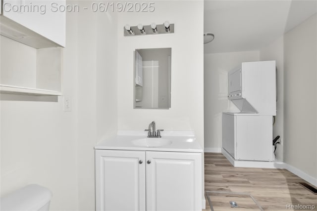 25044 Comfort, Center Line, MI 48015 - bathroom featuring stacked washer / dryer, vanity, and wood finished floors