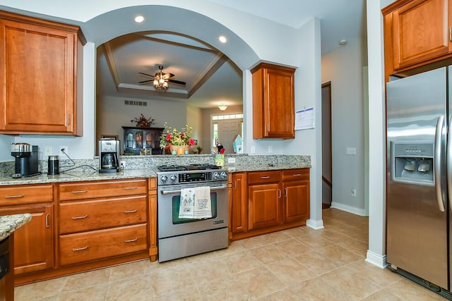 8734 Oakland Hills Cir Unit 6, Portage, MI 49024 - kitchen with appliances with stainless steel finishes, brown cabinets, a raised ceiling, ceiling fan, and arched walkways