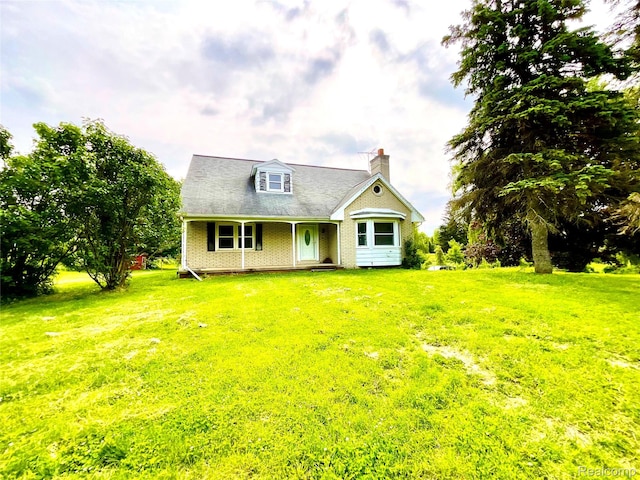 3615 N Mill Rd, Dryden, MI 48428 - view of front of house with covered porch, a chimney, a front yard, and brick siding