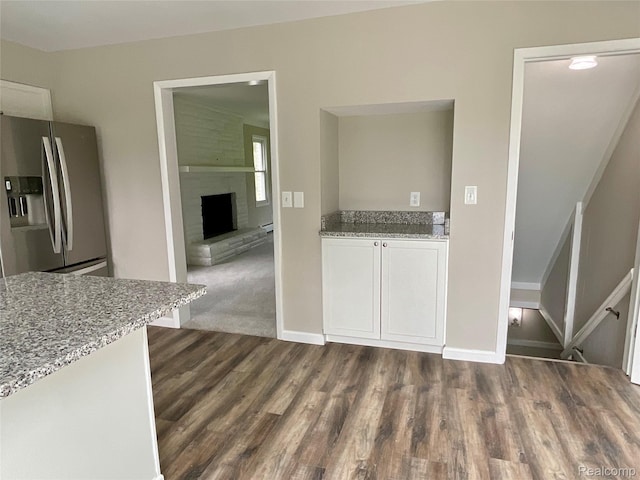 3615 N Mill Rd, Dryden, MI 48428 - kitchen featuring stainless steel refrigerator with ice dispenser, light stone countertops, white cabinets, and dark wood-style flooring