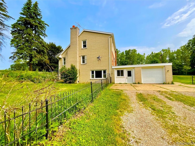 3615 N Mill Rd, Dryden, MI 48428 - view of side of home with concrete driveway, brick siding, and a chimney