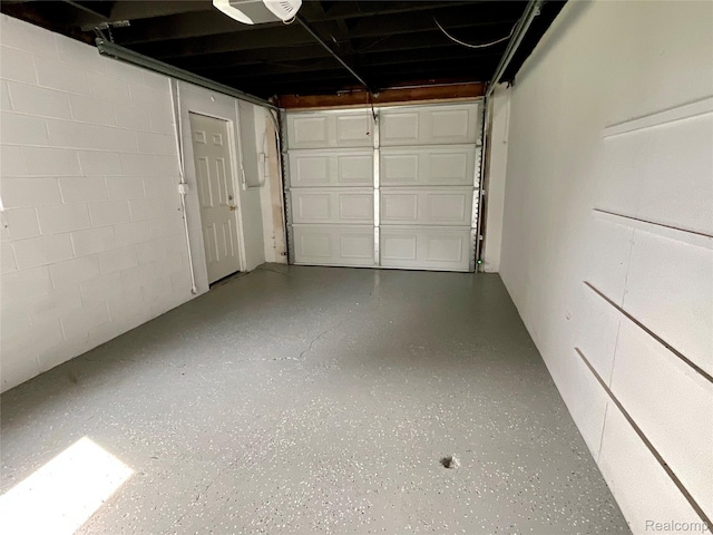 3615 N Mill Rd, Dryden, MI 48428 - garage featuring a garage door opener and concrete block wall