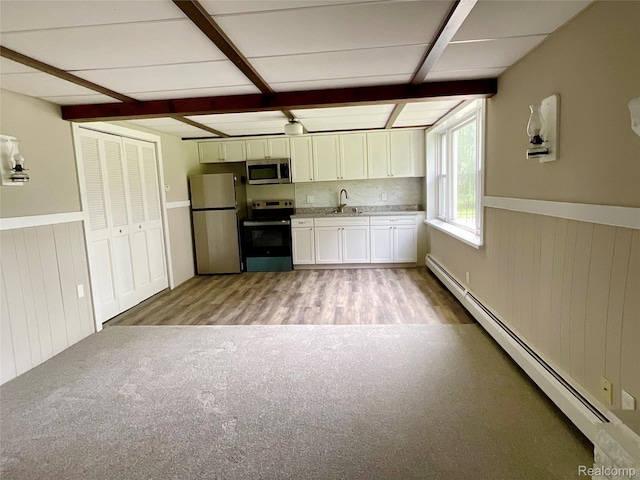 3615 N Mill Rd, Dryden, MI 48428 - kitchen featuring appliances with stainless steel finishes, baseboard heating, light wood-style flooring, wainscoting, and white cabinetry