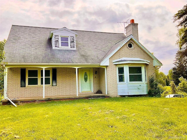 3615 N Mill Rd, Dryden, MI 48428 - view of front of home with a front lawn, brick siding, a chimney, and a porch