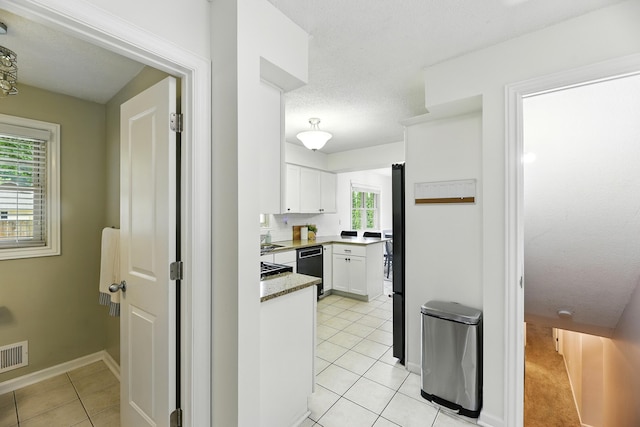 1548 Old Hickory Ln, Saint Joseph, MI 49085 - kitchen with white cabinets, dishwashing machine, light tile patterned flooring, and freestanding refrigerator