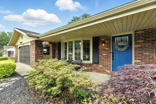 1548 Old Hickory Ln, Saint Joseph, MI 49085 - property entrance with brick siding, a garage, driveway, and a porch