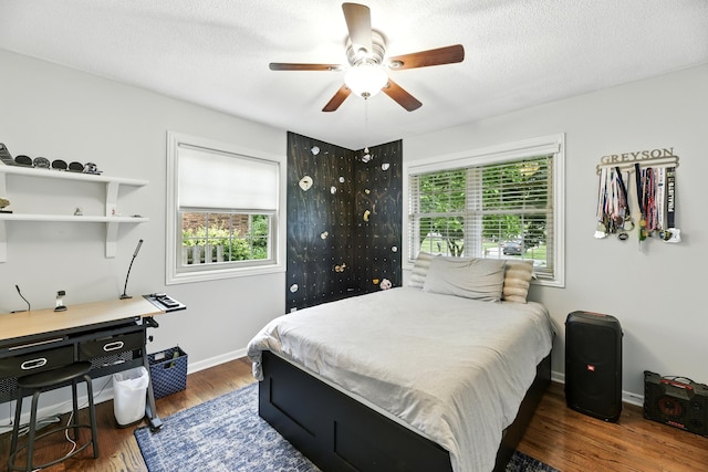 1548 Old Hickory Ln, Saint Joseph, MI 49085 - bedroom with multiple windows, wood finished floors, a ceiling fan, and a textured ceiling